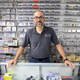Jerry Robles at the counter in front of the store’s impressive library of classic games.